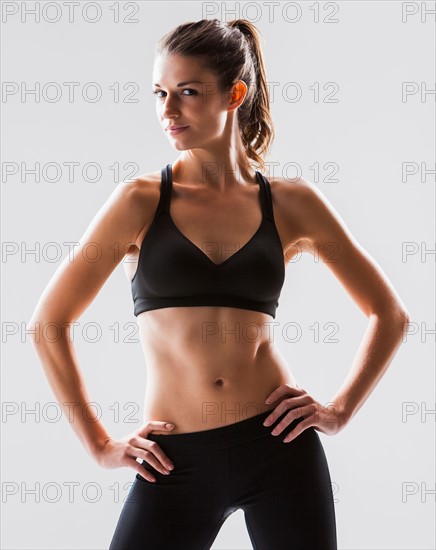 Portrait of young woman exercising, studio shot. Photo : Mike Kemp