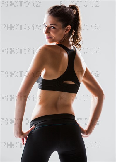 Portrait of young woman exercising, studio shot. Photo : Mike Kemp