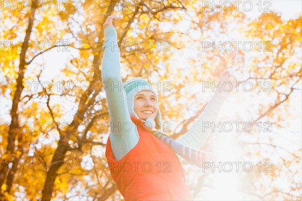 Happy young woman spinning in autumn forest. Photo: Mike Kemp