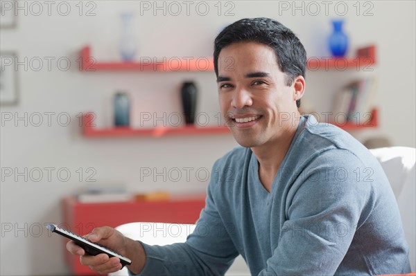 Portrait of smiling mid adult man at home. Photo : Dan Bannister