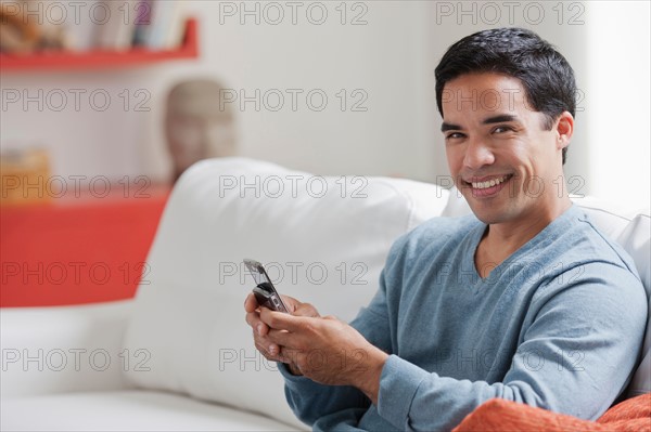 Man texting in living room. Photo: Dan Bannister