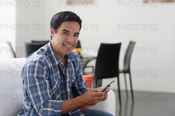 Man texting in living room. Photo : Dan Bannister