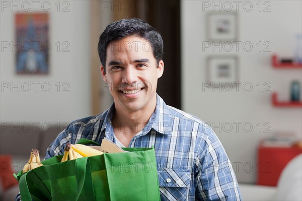Portrait of man with shopping bags. Photo : Dan Bannister