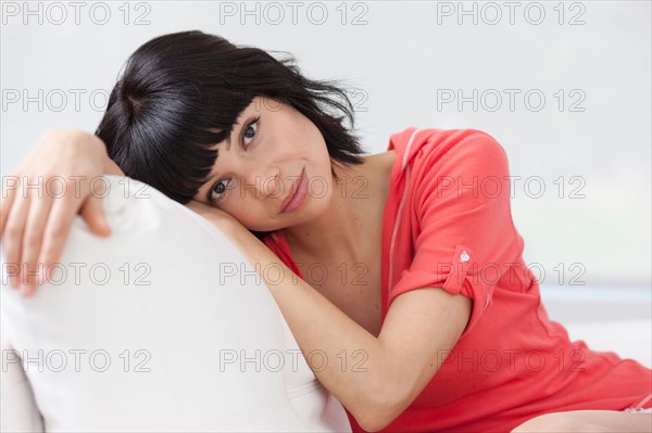 Young woman sitting on sofa. Photo: Dan Bannister