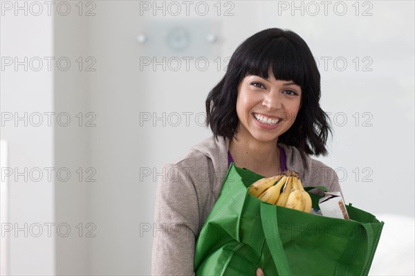 Portrait of young woman with shopping bag. Photo : Dan Bannister