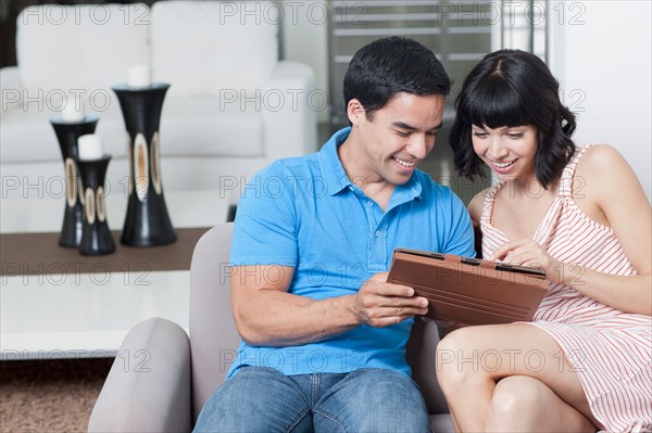 Young couple looking at photos. Photo : Dan Bannister