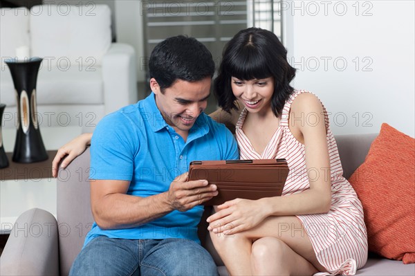 Young couple looking at photos. Photo : Dan Bannister