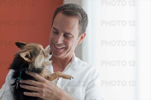 Mature man playing with dog. Photo : Dan Bannister