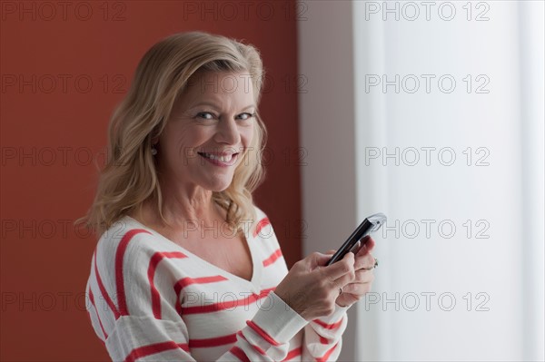 Portrait of mature woman texting. Photo : Dan Bannister