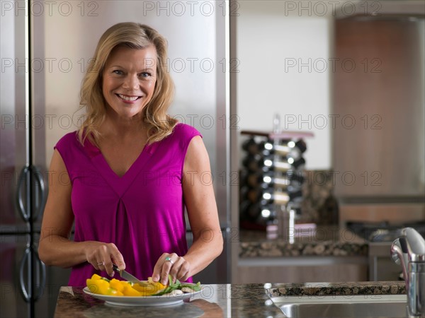 Portrait of mature woman preparing salad. Photo: Dan Bannister