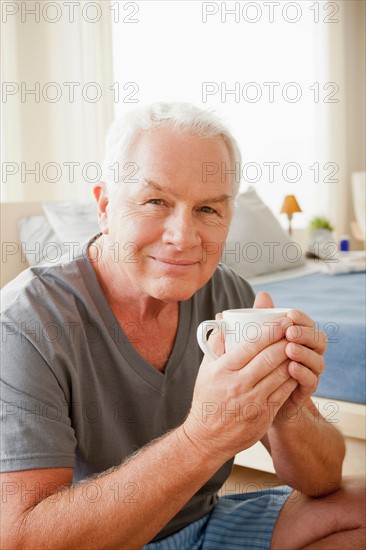 Senior man holding mug. Photo : Rob Lewine