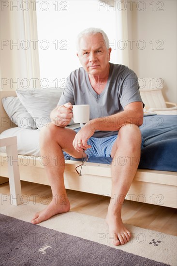 Senior man holding mug. Photo : Rob Lewine