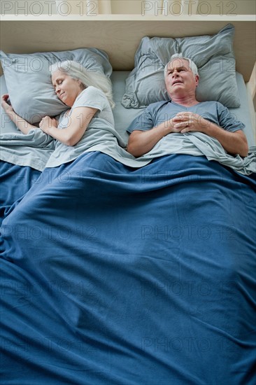 Senior couple sleeping in bed. Photo : Rob Lewine