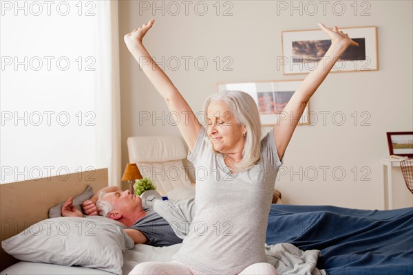 Senior woman stretching after waking up. Photo : Rob Lewine