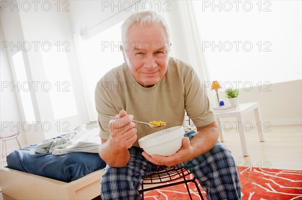 Senior man eating cereal from bowl. Photo: Rob Lewine