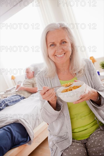 Senior woman eating cereal from bowl. Photo: Rob Lewine
