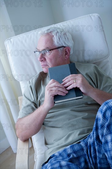 Portrait of senior man holding book. Photo: Rob Lewine