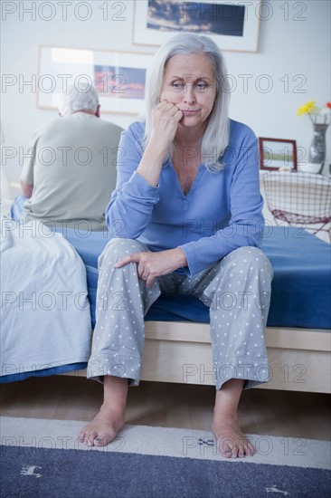 Senior couple after quarrel sitting on bed. Photo : Rob Lewine