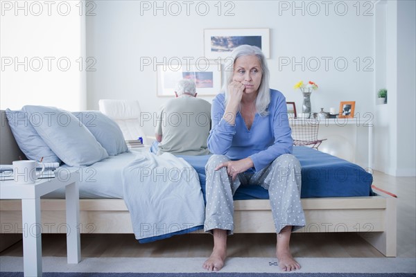 Senior couple after quarrel sitting on bed. Photo : Rob Lewine