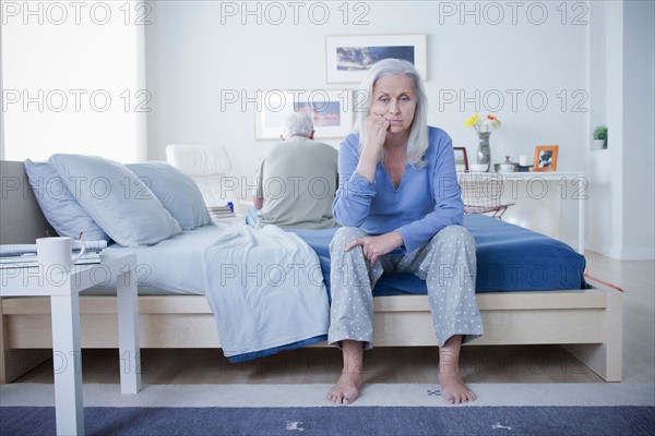 Senior couple after quarrel sitting on bed. Photo : Rob Lewine