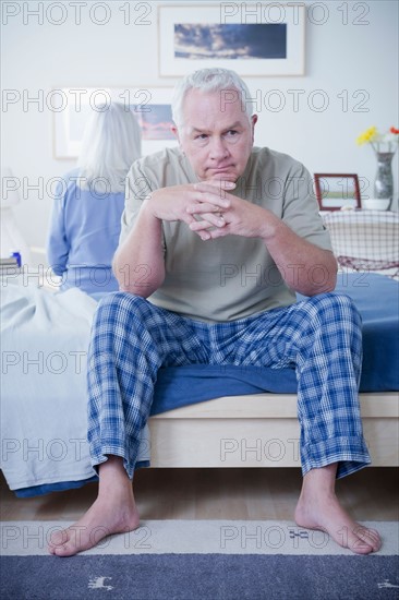 Senior couple after quarrel sitting on bed. Photo : Rob Lewine