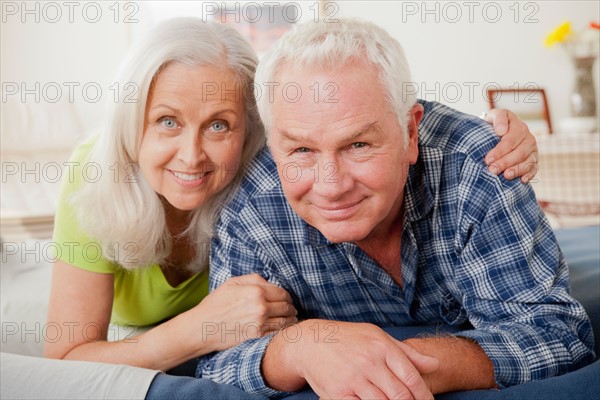 Portrait of senior couple laying on bed. Photo : Rob Lewine