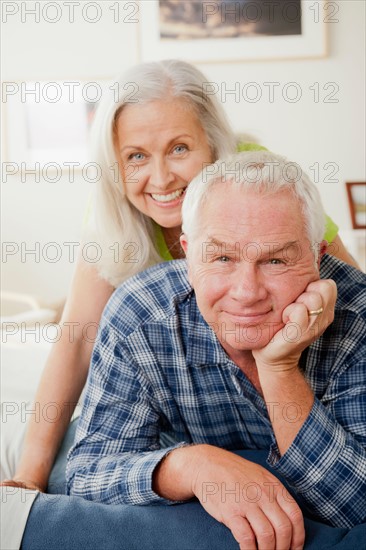 Portrait of senior couple laying on bed. Photo : Rob Lewine