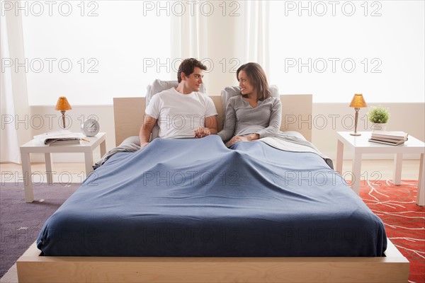 Couple cuddling in bed. Photo: Rob Lewine