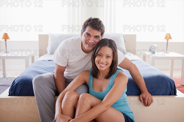 Couple in embrace sitting in bedroom. Photo: Rob Lewine