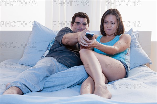 Couple sitting on bed and watching tv. Photo : Rob Lewine