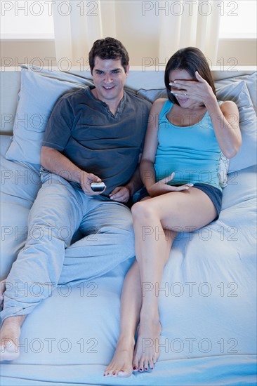 Couple sitting on bed and watching tv. Photo : Rob Lewine