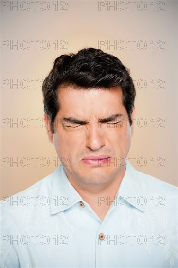 Portrait of man frowning with closed eyes. Photo : Rob Lewine