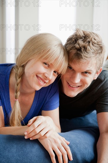 Portrait of couple lying on bed and smiling. Photo : Rob Lewine