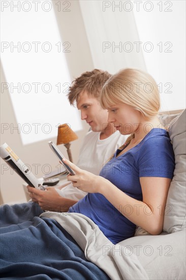 Couple sitting in bed reading. Photo : Rob Lewine