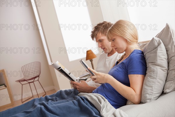 Couple sitting in bed reading. Photo : Rob Lewine