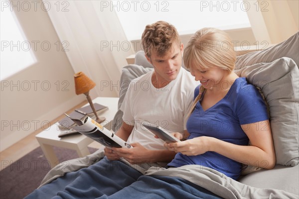 Couple sitting in bed reading. Photo : Rob Lewine