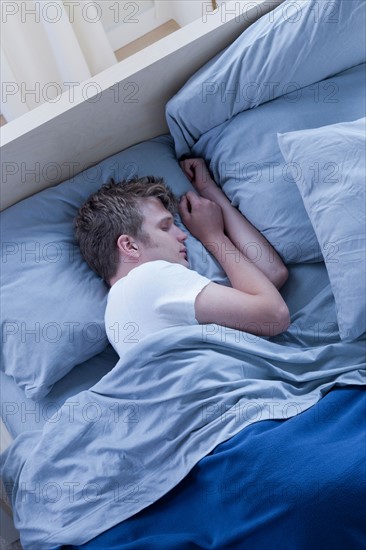 Elevated view of man sleeping on bed. Photo: Rob Lewine