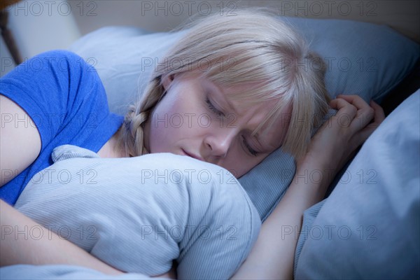 Woman sleeping on bed. Photo : Rob Lewine