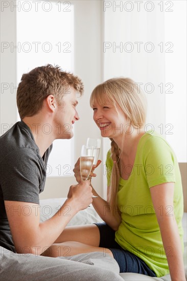 Couple enjoying champagne in bed. Photo : Rob Lewine