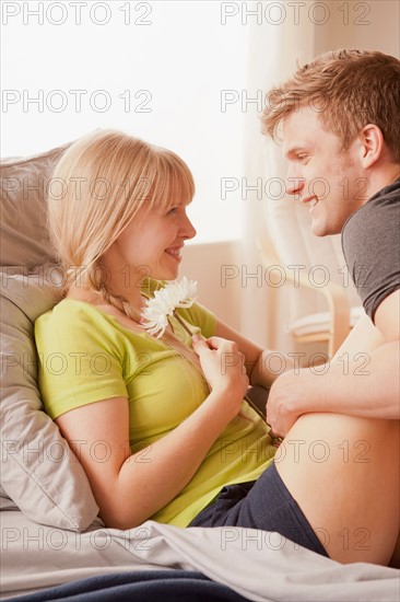 Man and woman sitting on bed and looking at each other. Photo: Rob Lewine