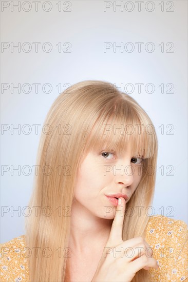 Portrait of woman with finger on her lips. Photo : Rob Lewine