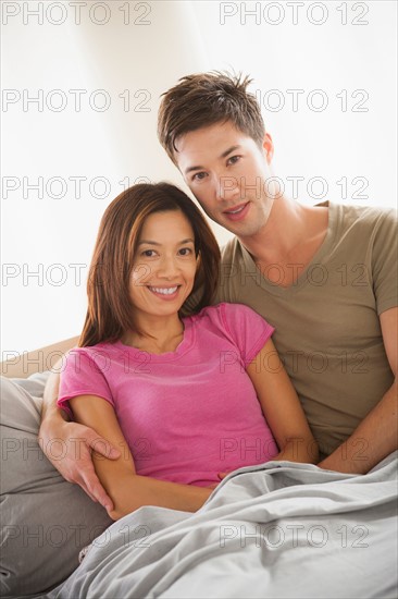 Portrait of couple sitting on bed. Photo: Rob Lewine