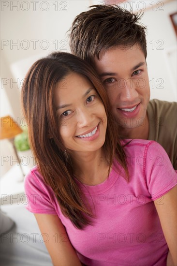 Portrait of couple sitting on bed. Photo : Rob Lewine