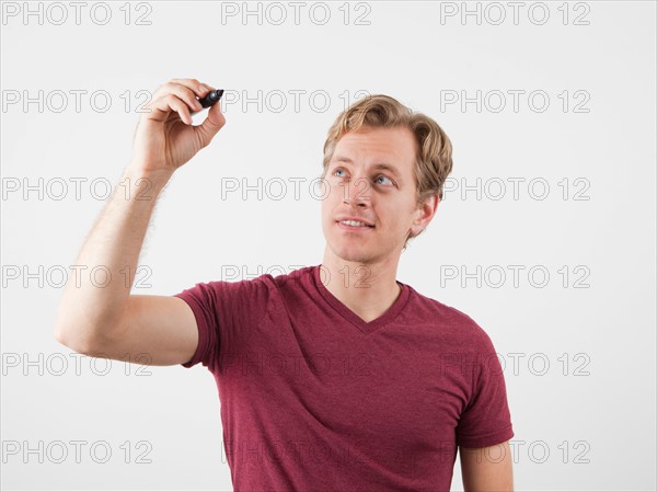 Portrait of man holding marker, ready to write. Photo : Jessica Peterson