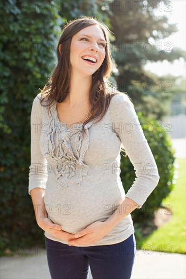 Pregnant mid adult woman standing in front of entrance door. Photo: Jessica Peterson