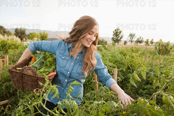 Portrait of young woman harvesting vegetables. Photo : Jessica Peterson