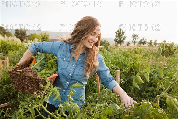 Portrait of young woman harvesting vegetables. Photo: Jessica Peterson