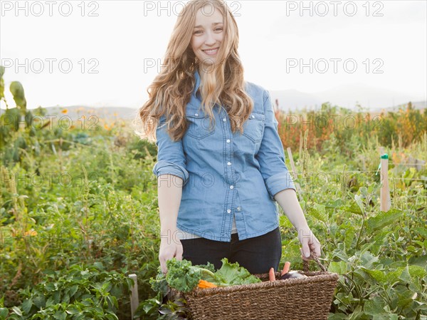 Portrait of young woman harvesting vegetables. Photo: Jessica Peterson