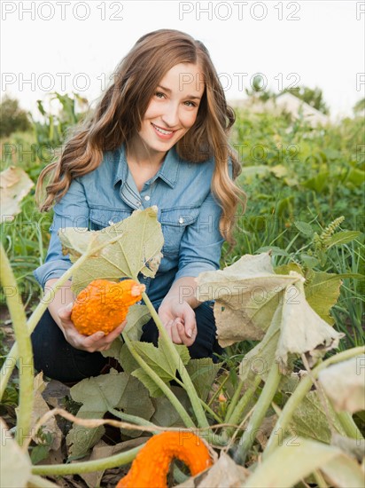 Portrait of young woman harvesting squash. Photo : Jessica Peterson