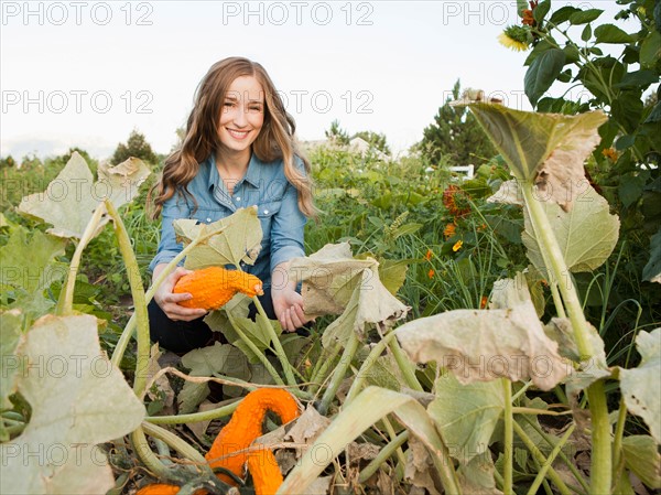 Portrait of young woman harvesting squash. Photo : Jessica Peterson